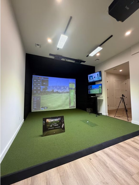 Completed golf simulator installation by the ynVISION team — full hitting area with impact screen, overhead projection, turf and wall-mounted displays Completed custom golf simulator installation by ynVISION